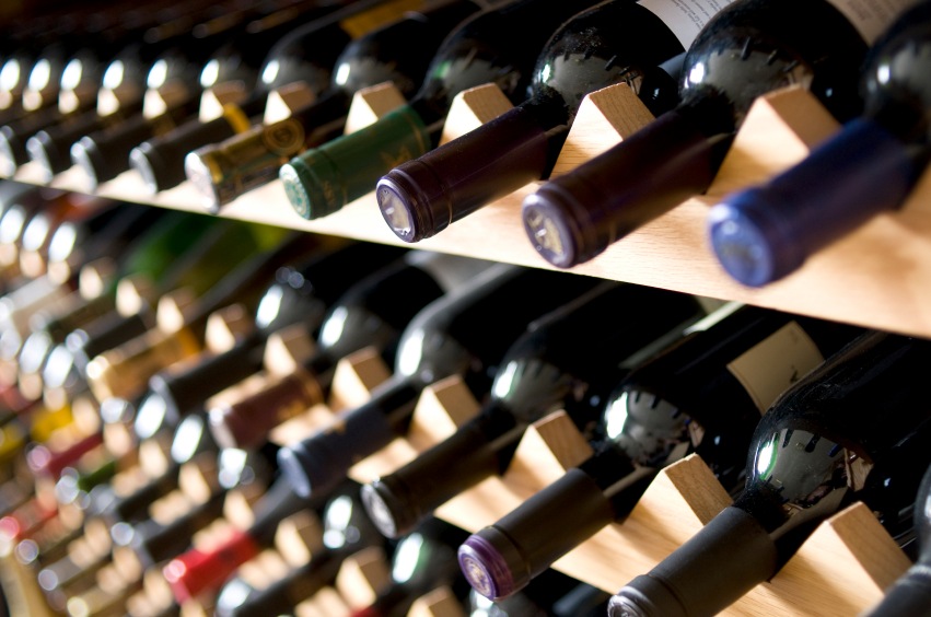Neck of wine bottles displayed on wine rack